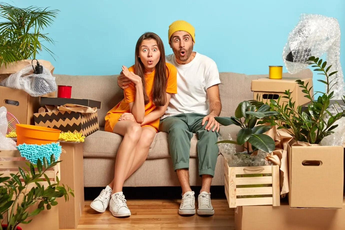 Снимок молодой ошарашенной семейной пары, сделанный в помещении.