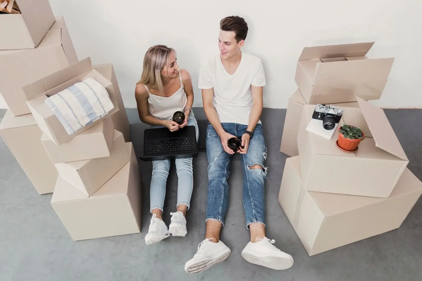 Пара, снятая с верхнего ракурса, сидит на полу.